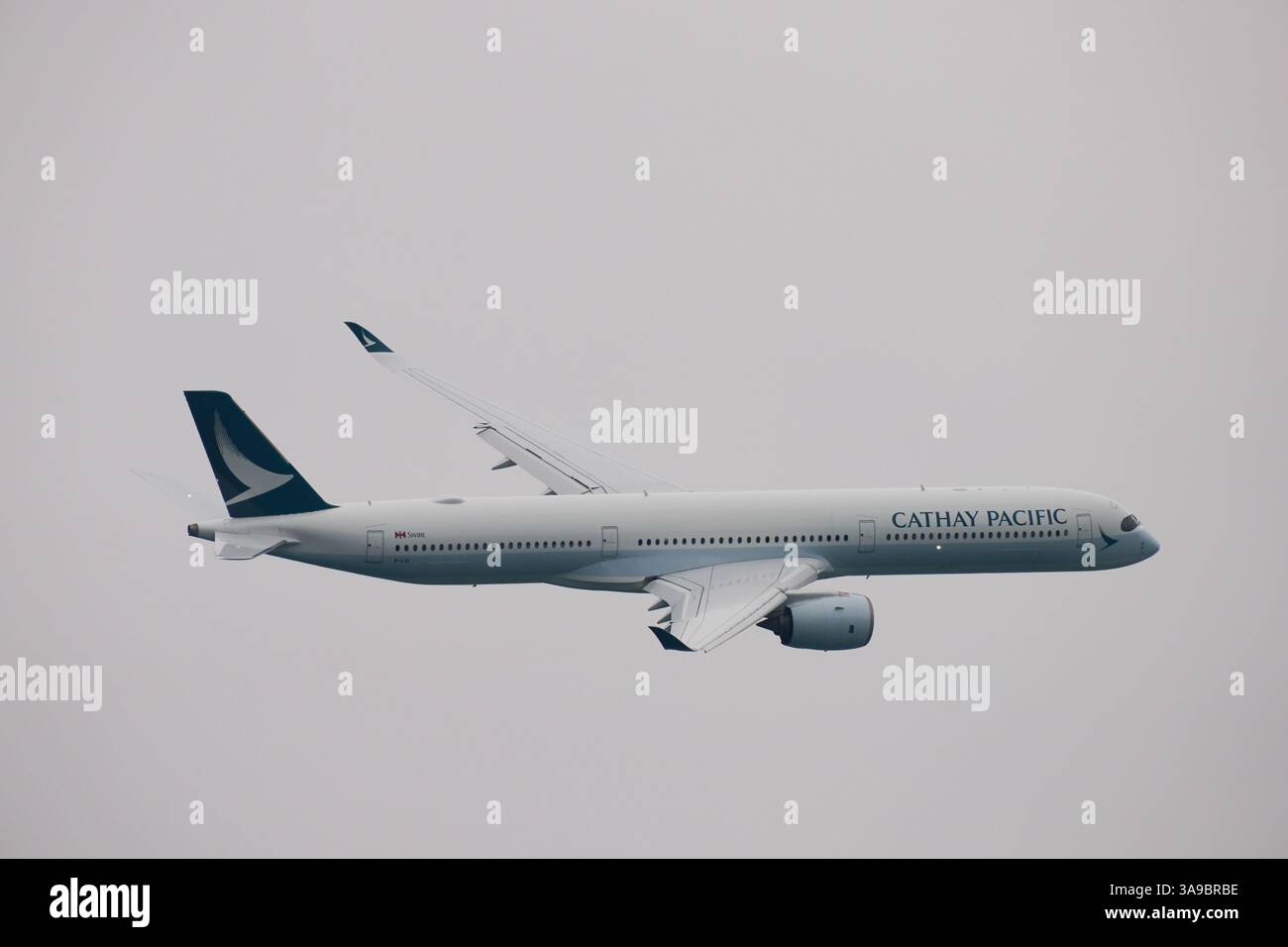 Cathay Pacific special flight CX8100 (Airbus 350-1000) flying low across the harbour to celebrate the 100th anniversary of Kai Tak Airport (1925-1998) Stock Photo