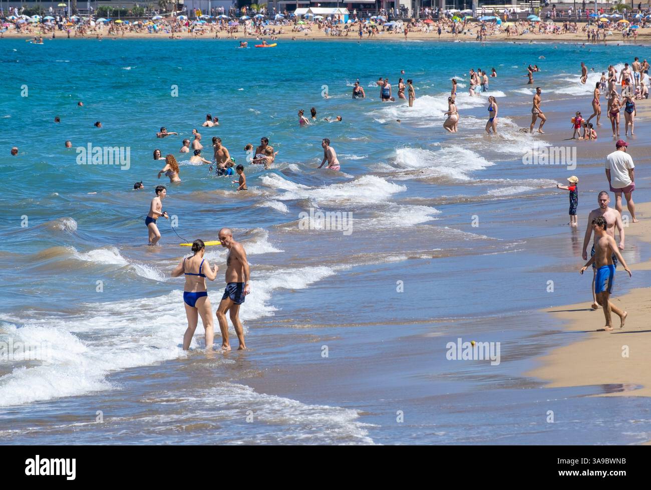 Gran Canaria, Canary Islands, Spain, 30th March 2025. Tourists, many British and German, join locals on a packed city beach in Las Palmas, the capital of Gran Canaria. Credit: Alan Dawson/Alamy Live News. Stock Photo