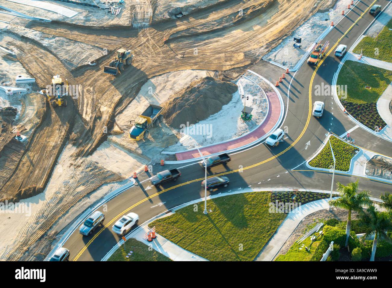 Driving traffic cars at roundabout intersection under construction ...