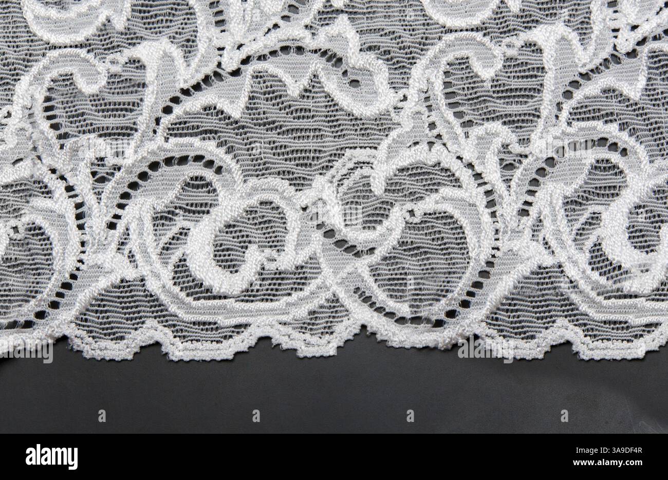 White lace with pattern in the manner of flower on black background Stock Photo
