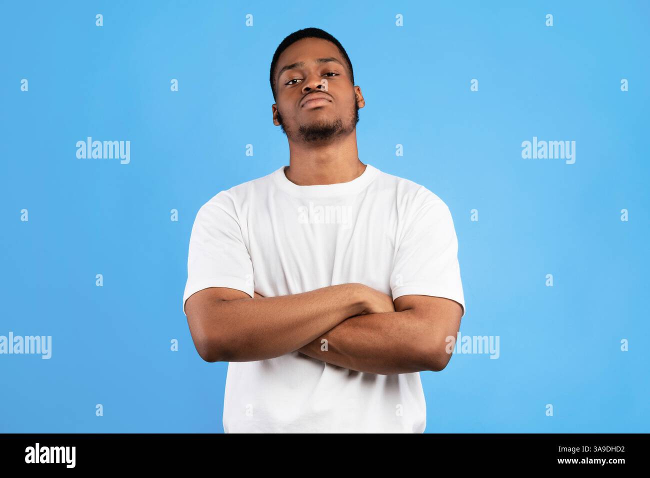 Cool Black Man Standing Crossing Hands Posing On Blue Background Stock Photo