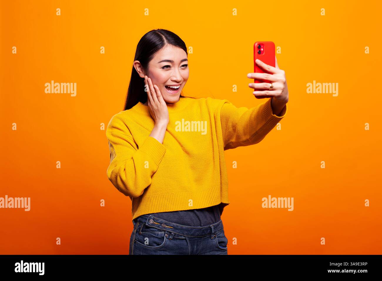 Gorgeous asian woman in a pullover sweater taking a selfie with her ...