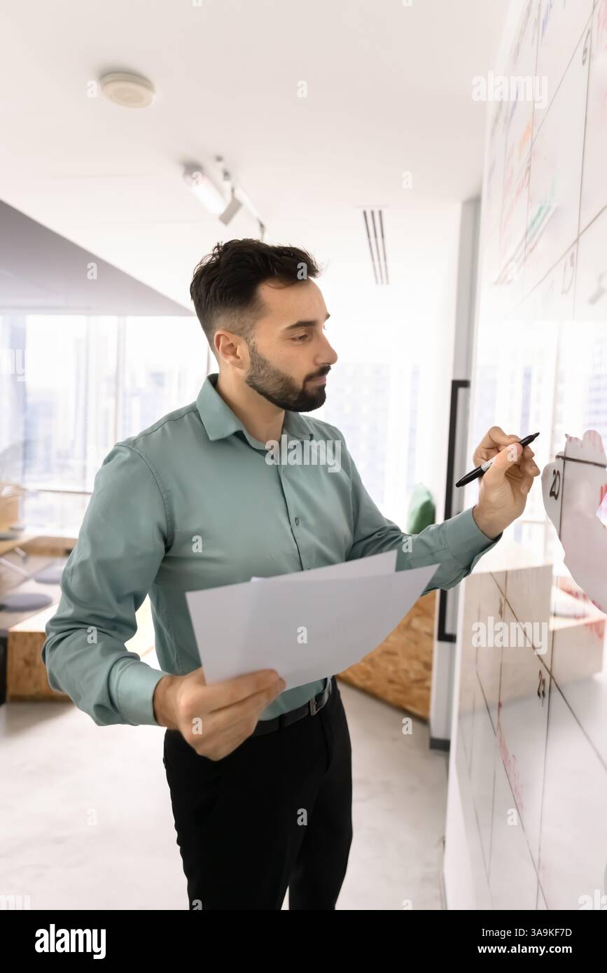 Serious Latin manager man using Kanban scrum board Stock Photo