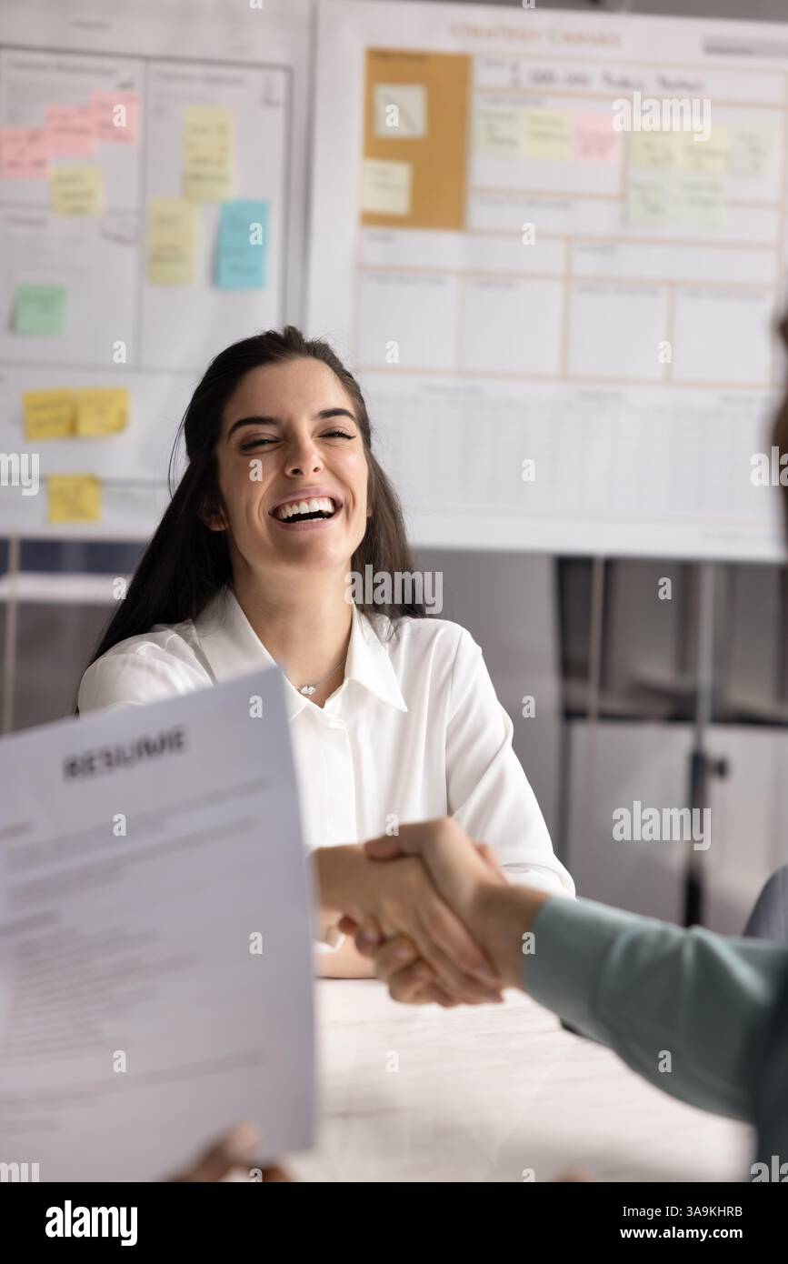 Cheerful Hispanic young applicant woman getting hired Stock Photo
