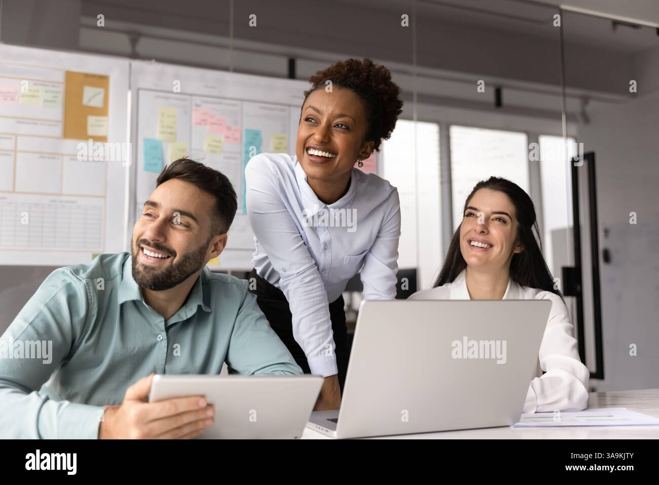 Happy multiethnic young project managers working on online project Stock Photo