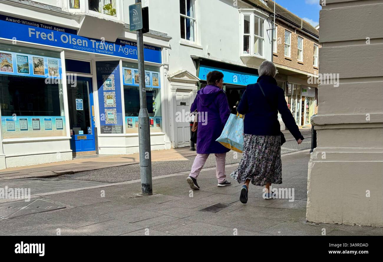 Woodbridge, Suffolk, UK - 30 March 2025 : Ladies walking past Fred Olsen Travel Agent. Hot Sunday afternoon. Stock Photo
