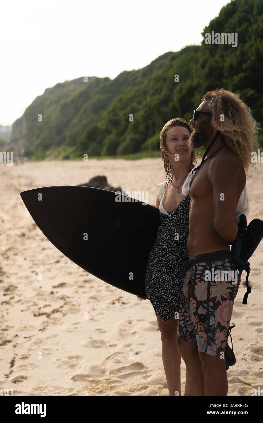 Friends with surfboard standing at beach Stock Photo