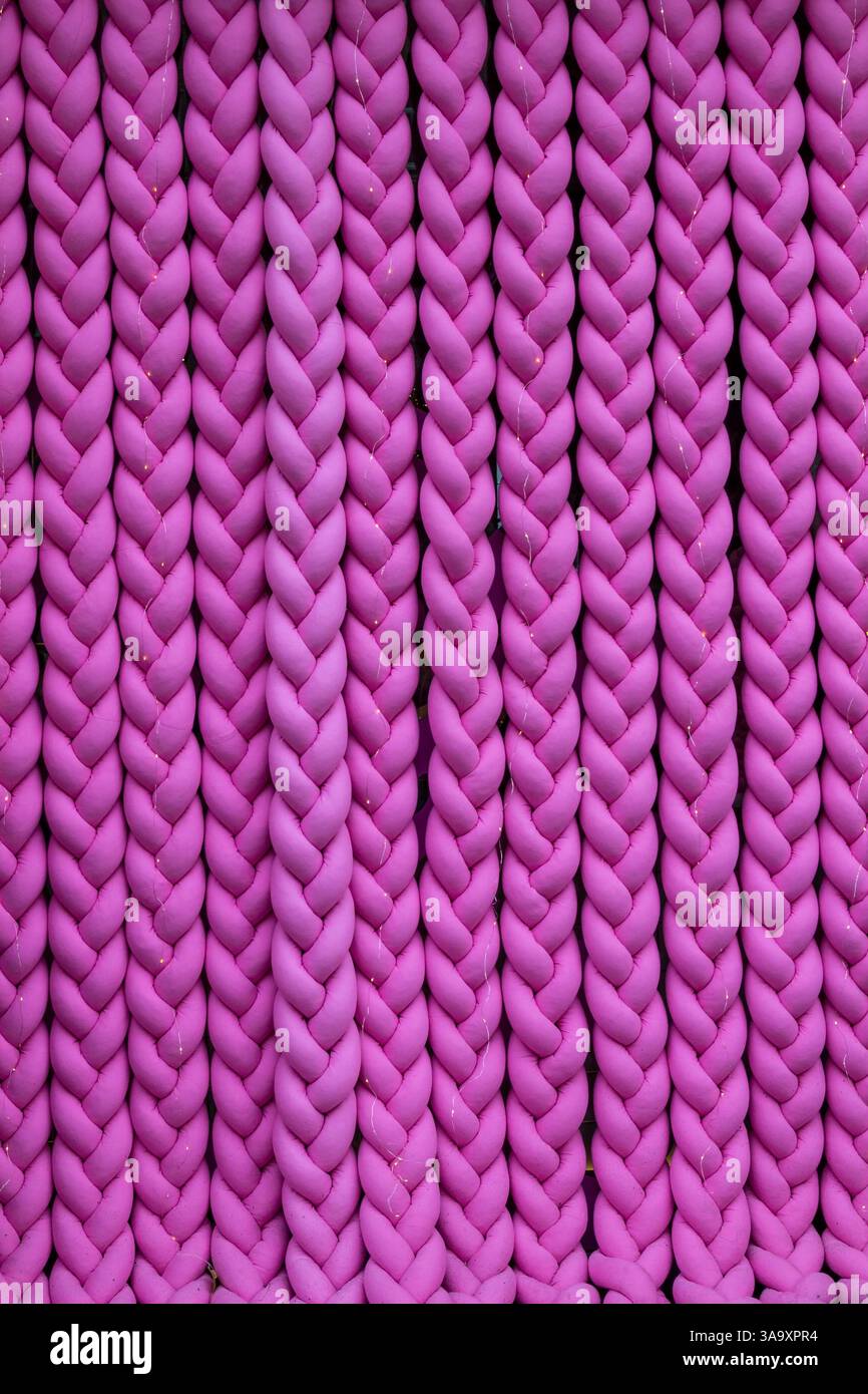 Knitted braids from pink fabric. Background Stock Photo