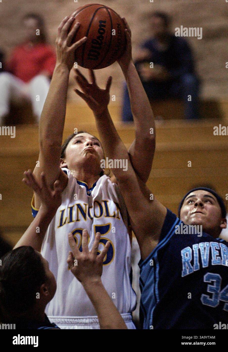 Lincoln's Emeri Eide grabs a rebound over River City's Rosa Verduzco, right 34,  during the first round game with River City  in the 14th Annual Lincoln High School Invitational at Lincoln High School Wednesday December 31 2003. Sacramento Bee/  Andy Alfaro  /ZUMA Press Stock Photo