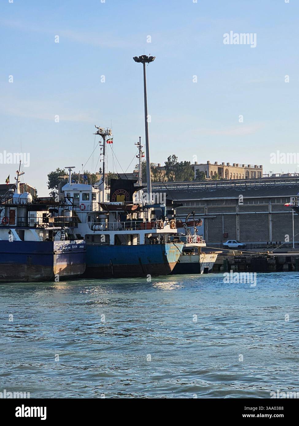 Option 1 (Focus on Detail): A detailed view of a boat's hull, showcasing its vibrant blue and red paint, along with essential nautical equipment like - Smartphone Captured Stock Image