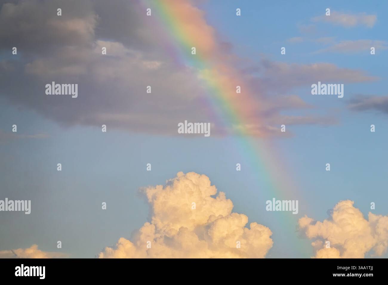 Capturing a vibrant rainbow gracefully arcing across a blue sky ...