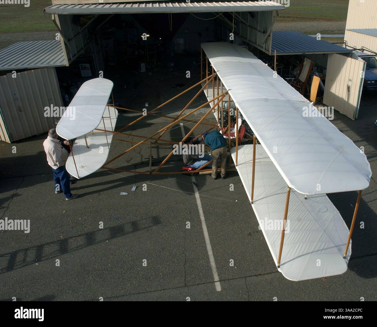 Tom Ivicevich , in green jacket, adjusts cables on his replica of a ...