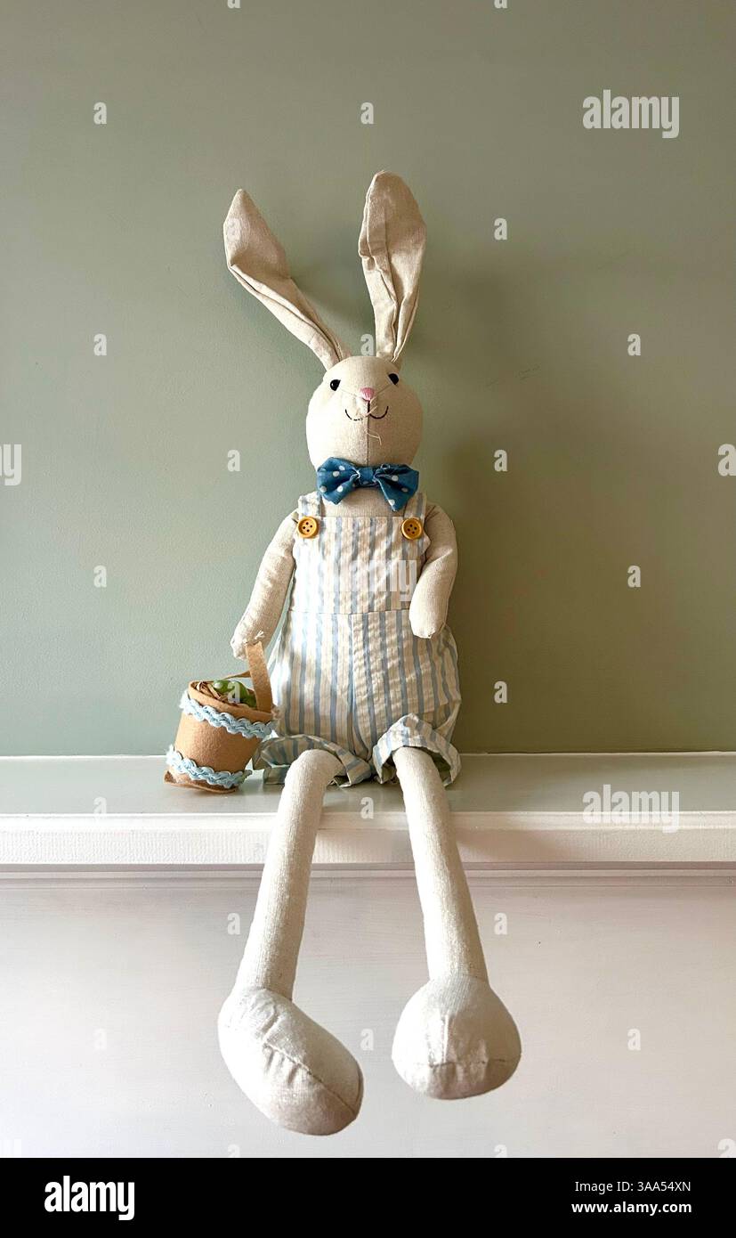 Cute stuffed Easter bunny holding a basket filled with colorful eggs. - Smartphone Captured Stock Image