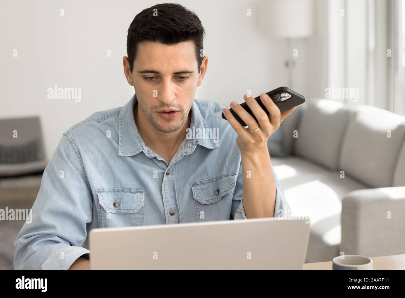 Man holding smartphone lead conversation using speakerphone Stock Photo