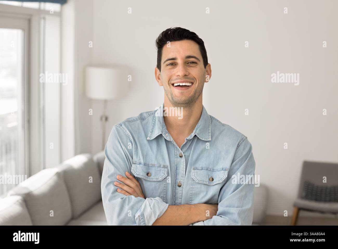 Hispanic man standing in contemporary living room Stock Photo