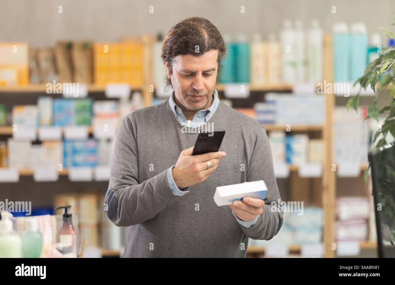 Man in pharmacy scans QR code on antibacterial ointment product Stock ...