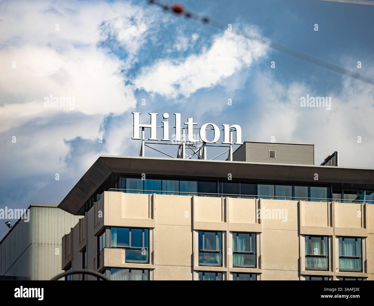 Hilton logo sign on the hotel building exterior of the Hilton Vienna Park. Multinational company in the hospitality industry. 5-star hotel for tourism Stock Photo
