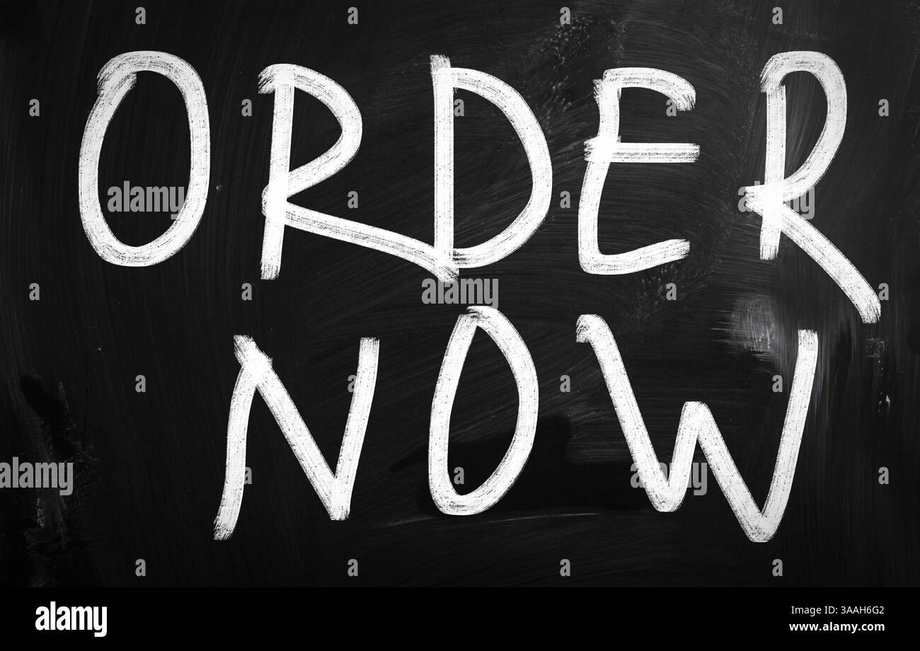 Order now handwritten with white chalk on a blackboard Stock Photo