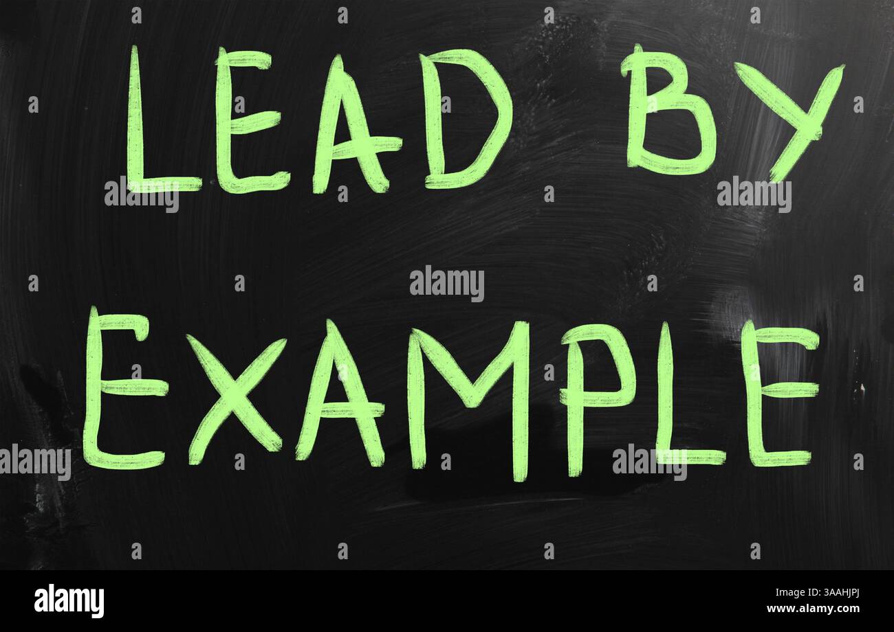 Lead by example handwritten with white chalk on a blackboard Stock Photo