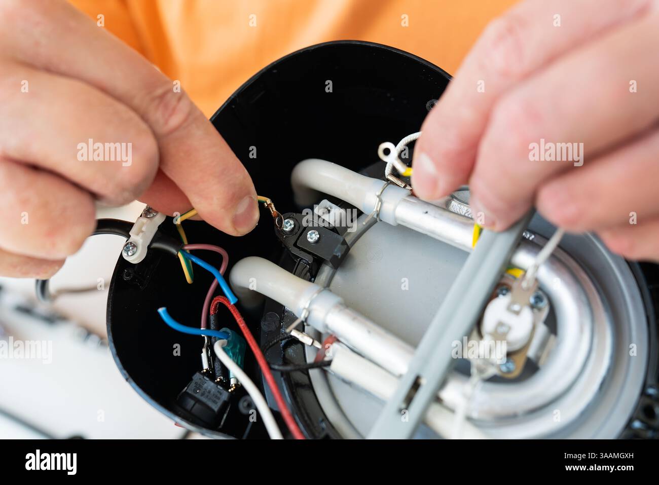 A person carefully repairs the internal wiring and components of a