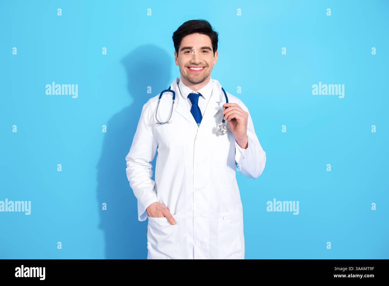 Confident doctor in white coat smiling with stethoscope and presenting ...