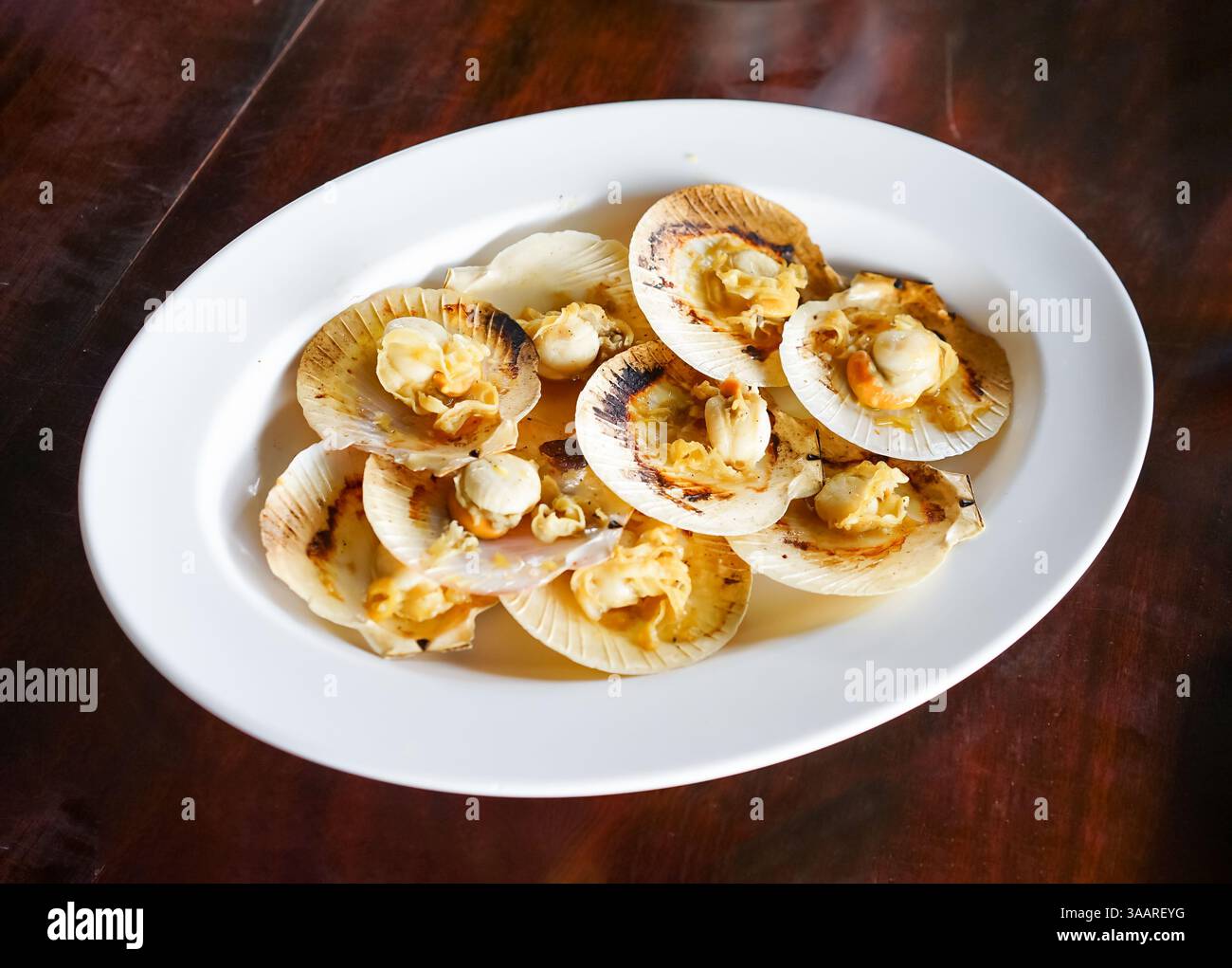 Grilled scallops in the shell with butter, a fresh seafood menu of a ...