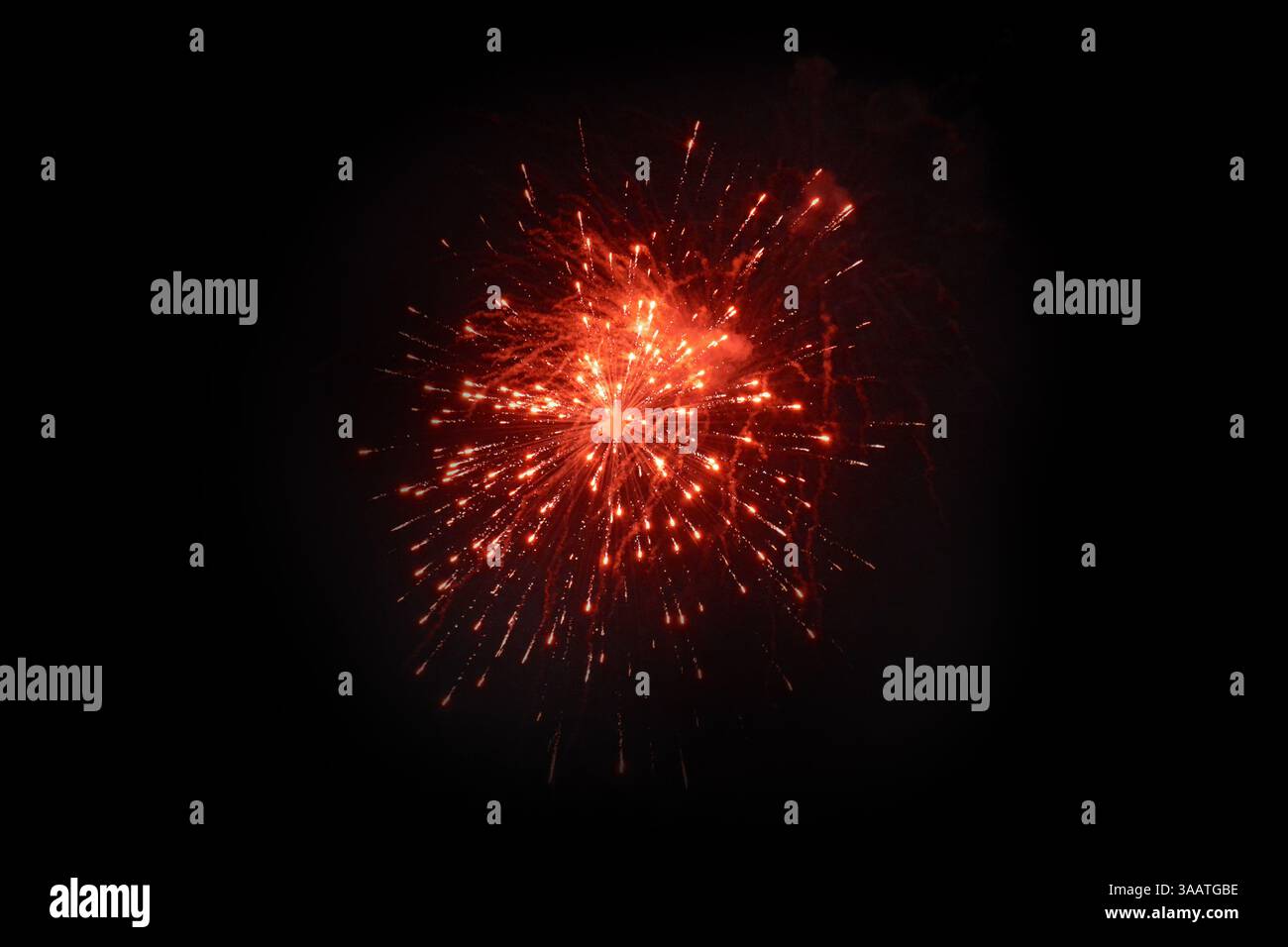 Single Red Firework Burst Against Night Sky Stock Photo
