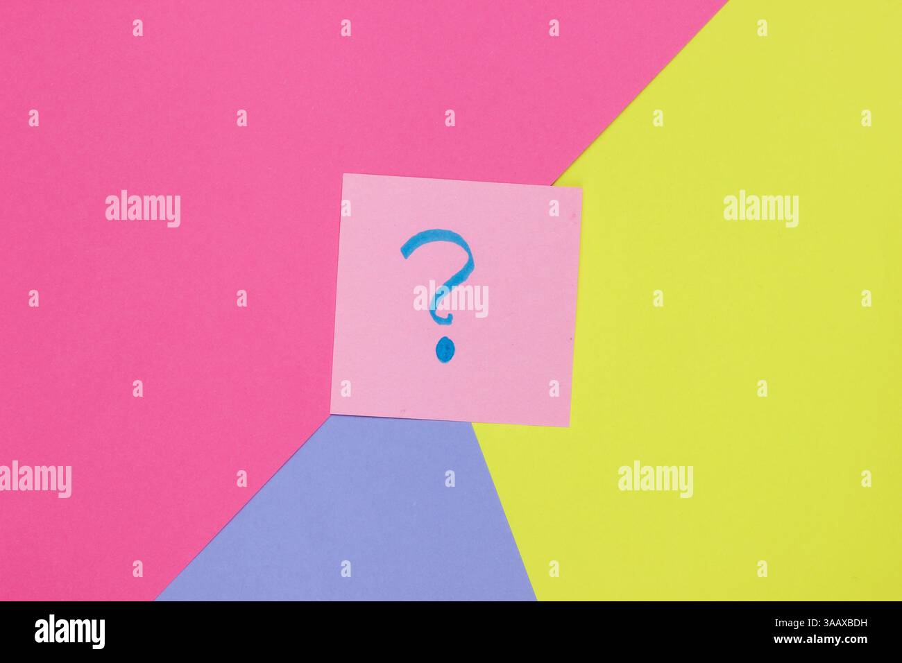 Memo piece of paper with drawn question marks on colored  background. Top view. Minimalism Stock Photo