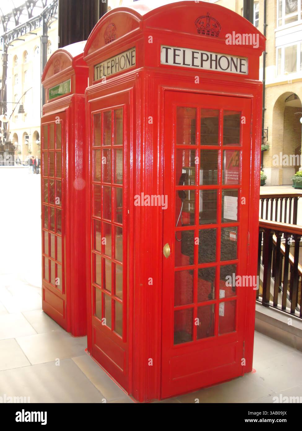 Two iconic red British telephone booths in an indoor setting Stock ...