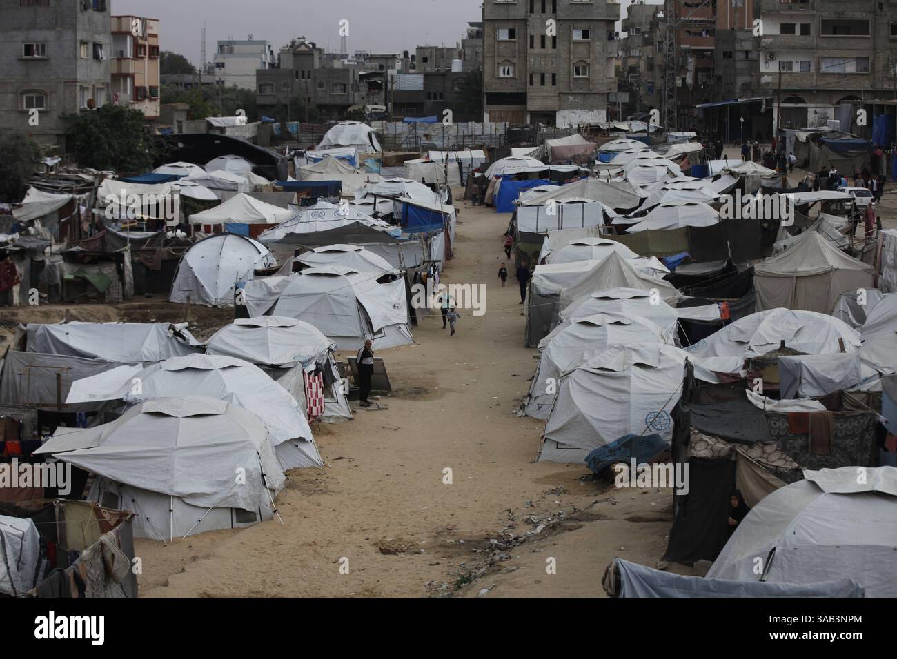 Palestinian children spend their time playing amidst the tents set up ...