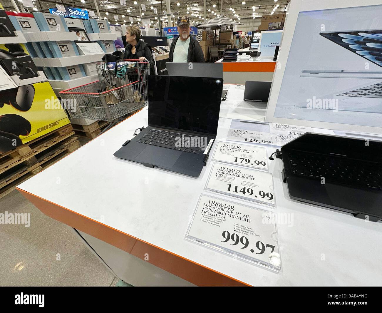 MacBook Air laptop sits on display as shoppers pass by in a Costco ...