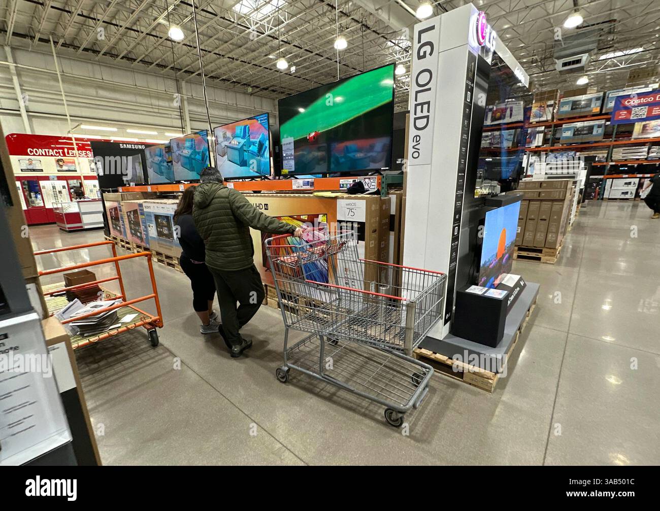 Shoppers consider big-screen televisions on display in a Costco ...