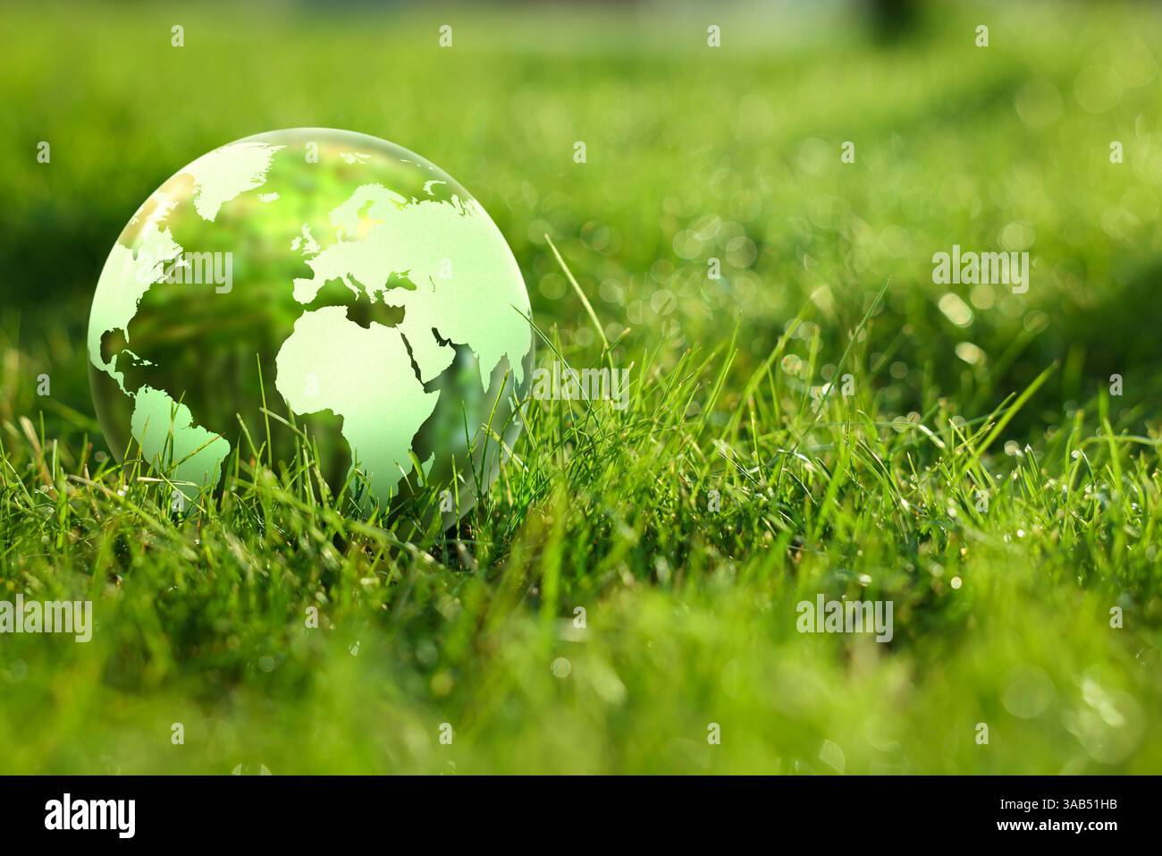 Earth globe in glass ball on green grass outdoors. Concept of ...