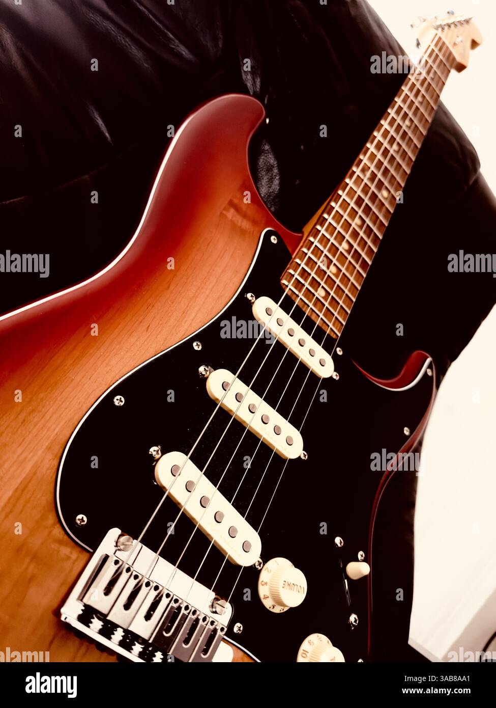 Electric Guitar. The guitar is placed on a black armchair, which gives the picture a complete impression. Guitar is loved by everyone. - Smartphone Captured Stock Image