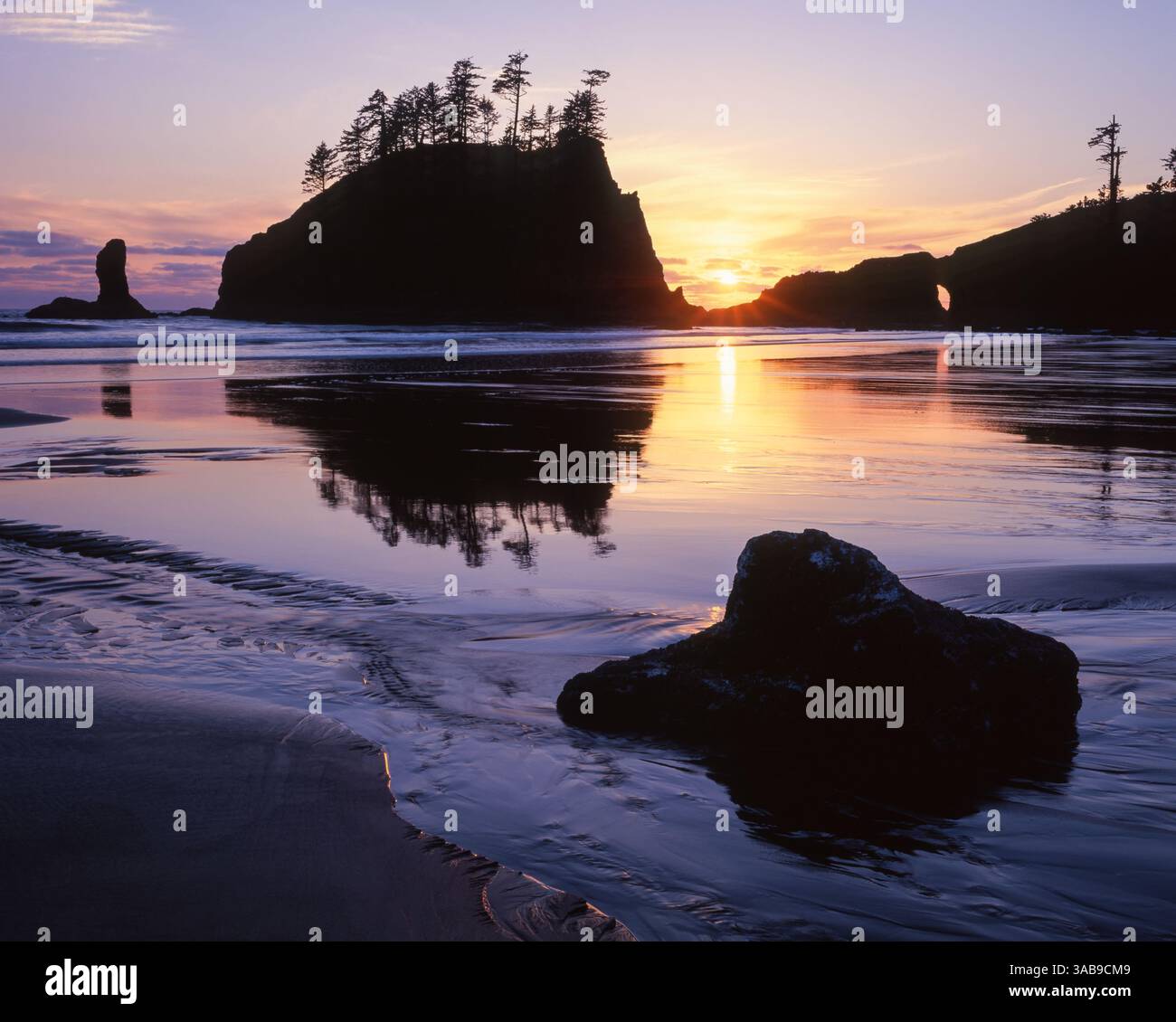 A dramatic sunset silhouettes a sea stack at Second Beach in Olympic ...
