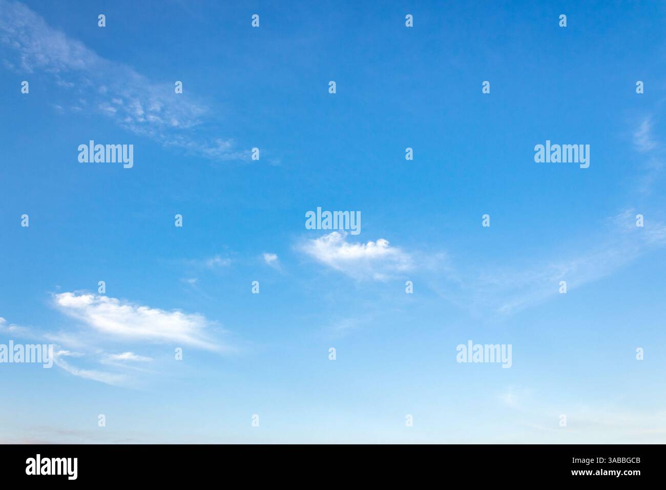 nature backdrop with blue sky and white fluffy clouds in morning light. bright and sunny weather forecast background Stock Photo