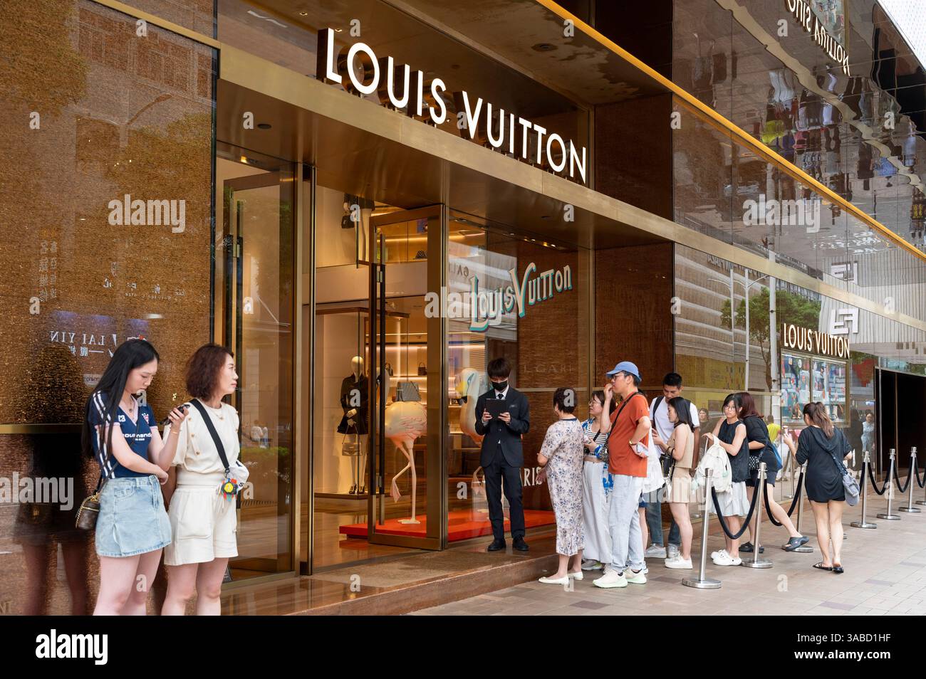 Shoppers queue up as they wait to enter the French luxury fashion brand ...