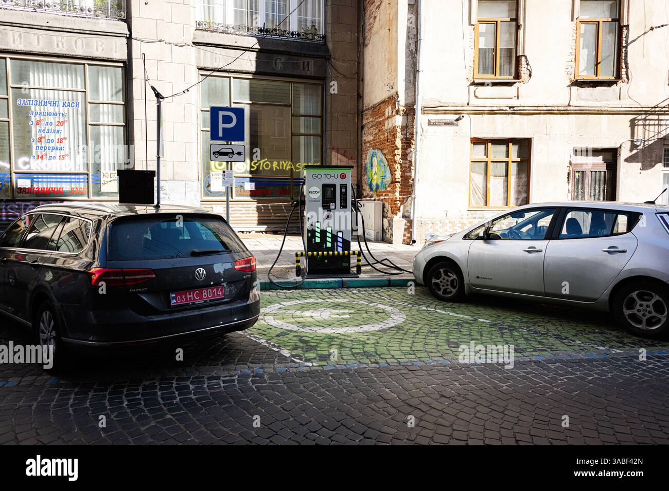 Lviv, Ukraine - April 01, 2025: Two cars parked and charging at an electric vehicle station in Lviv, Ukraine Stock Photo