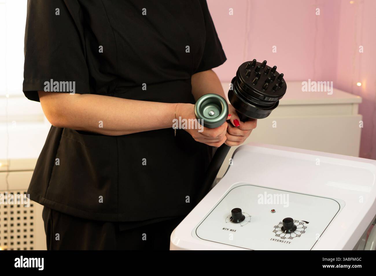 A therapist holding two cavitation device attachments near the control ...