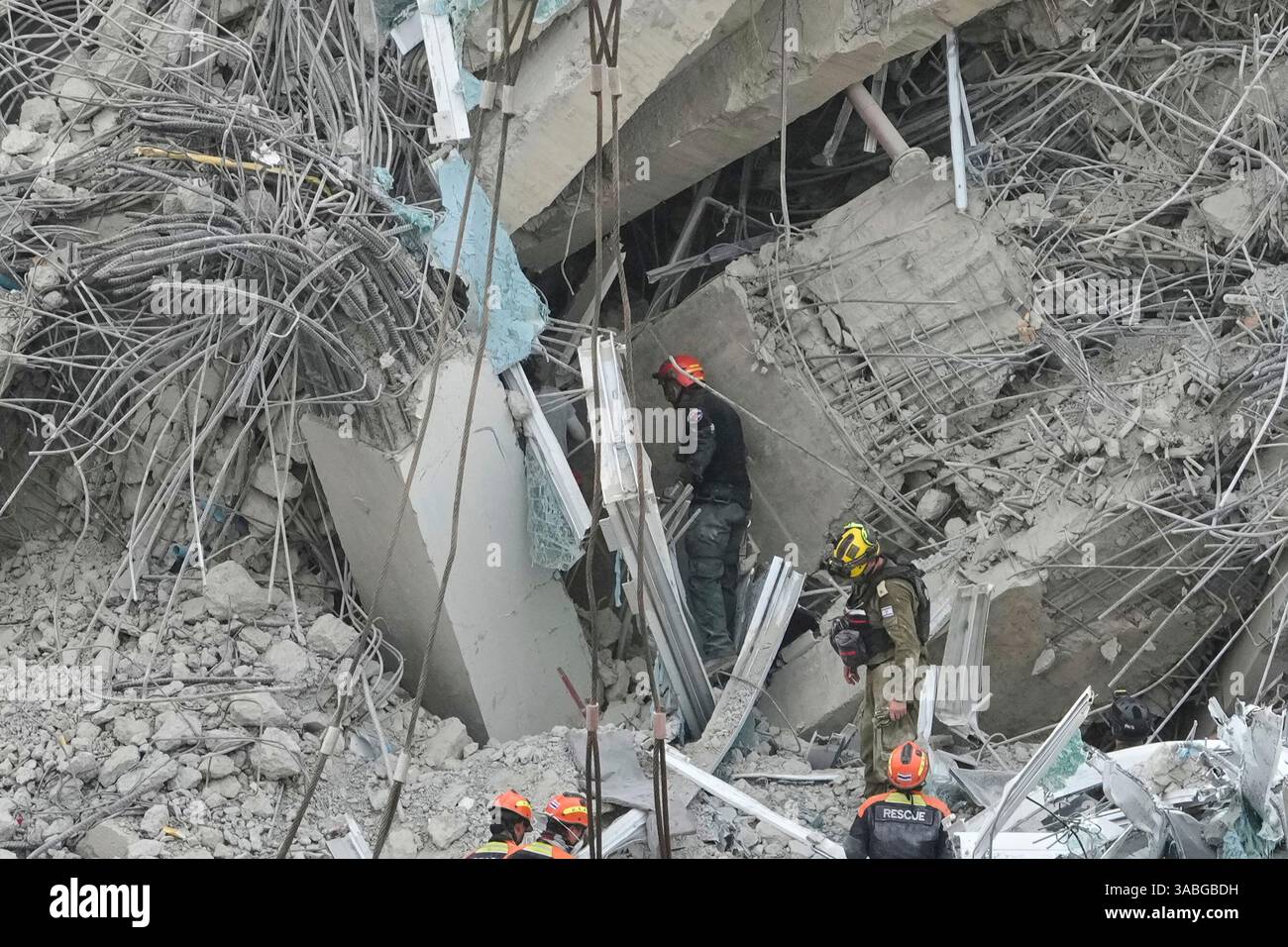 Rescuers scan the rubbles at the site of an under construction high ...
