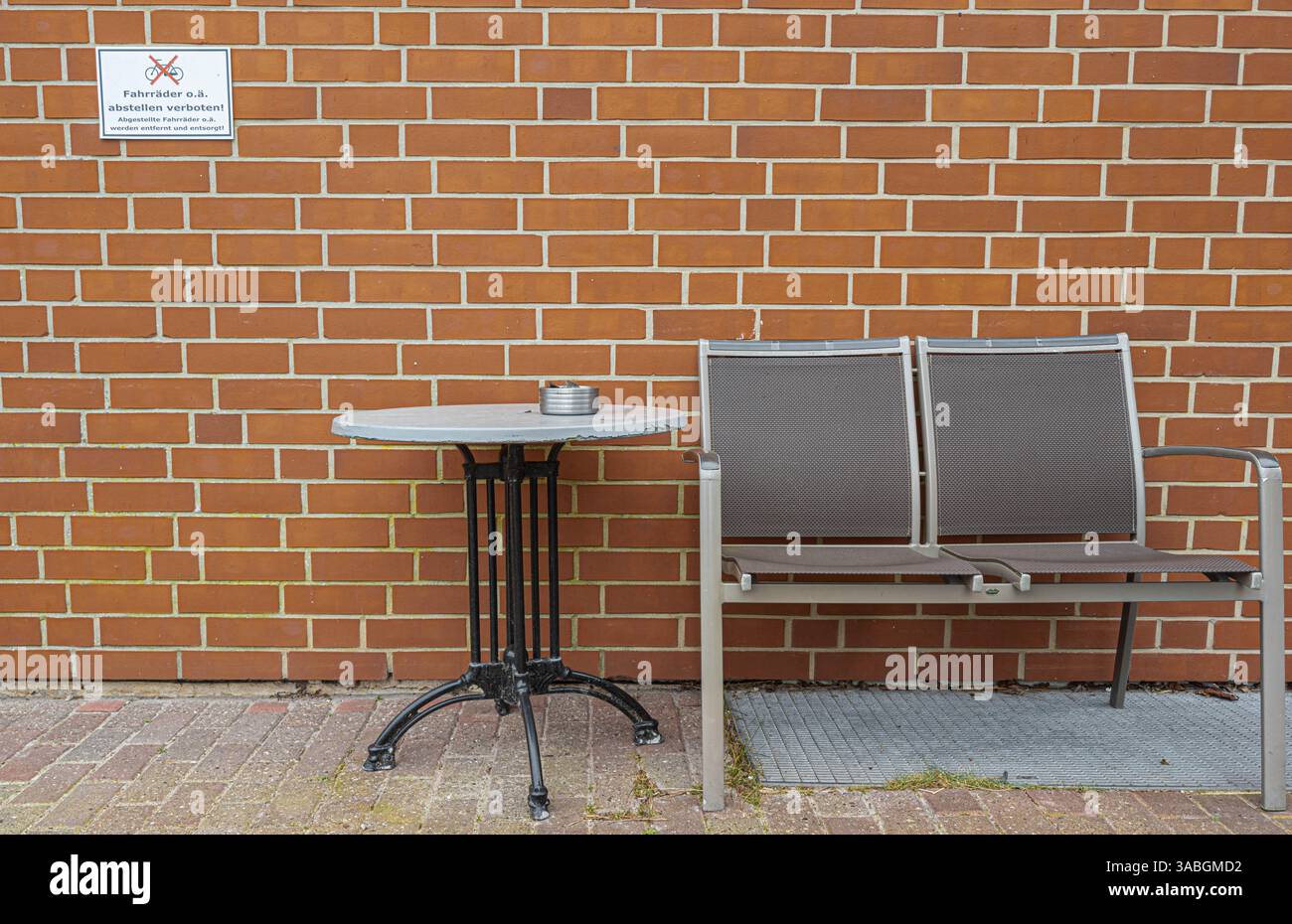 23 March 2025, Hamburg: A two-seater aluminum garden bench and a table ...