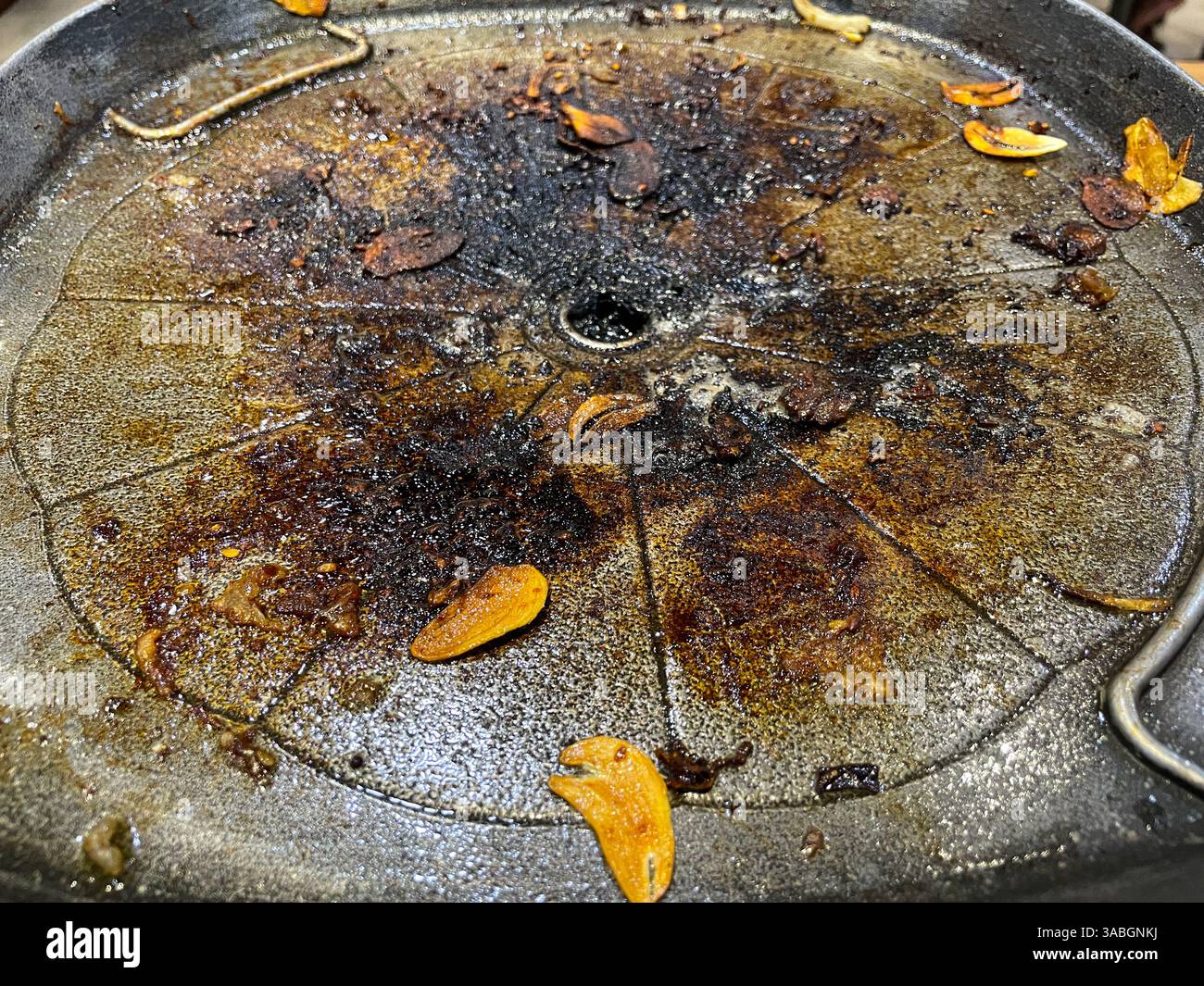 Burnt and used Korean-style grill pan in close up view as background - Smartphone Captured Stock Image
