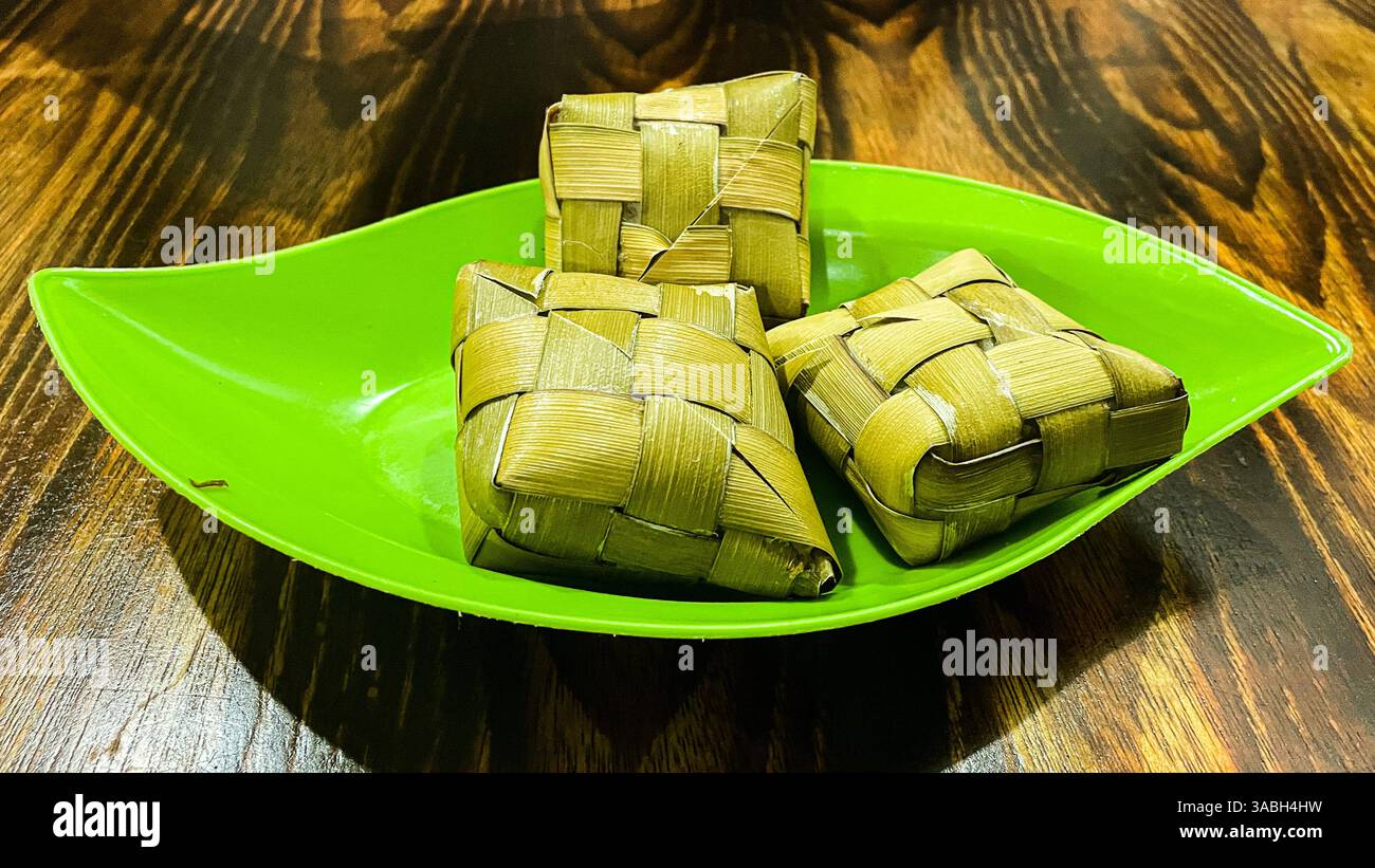 Ketupat or rice dumpling is indonesian traditional food serve on food container - Smartphone Captured Stock Image