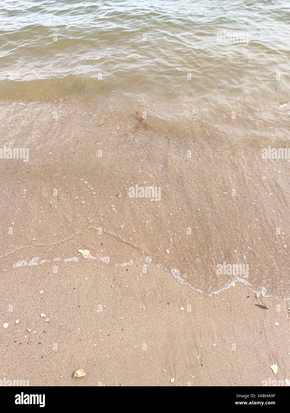 Soft wave of blue ocean on sandy beach. Background. - Smartphone Captured Stock Image