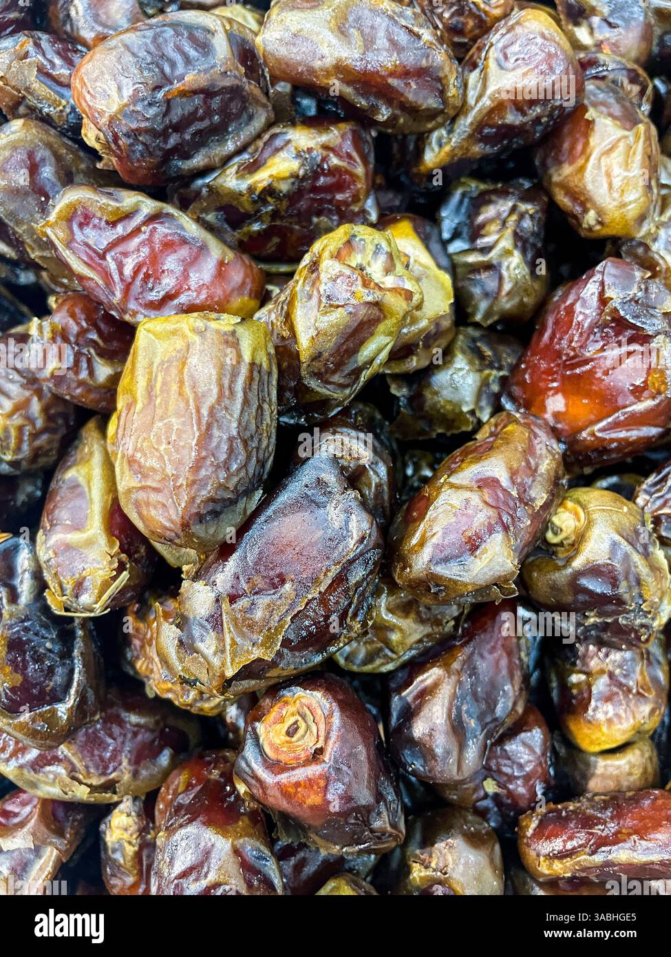 Full frame background top view of pile of appetizing dried date medjoul fruits displayed on market - Smartphone Captured Stock Image