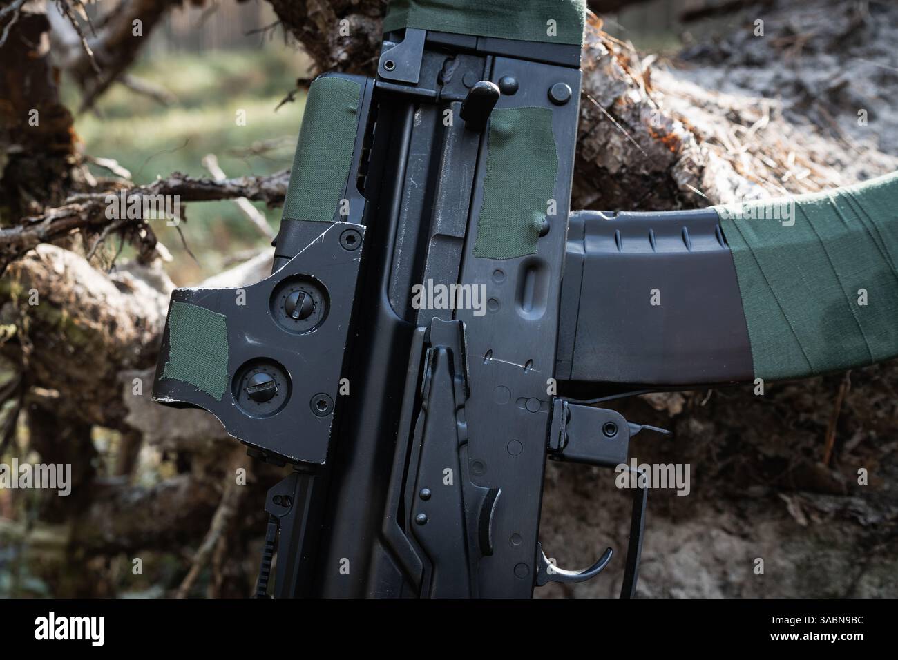 Close-up of modified firearm: green tape, holographic sight on ...