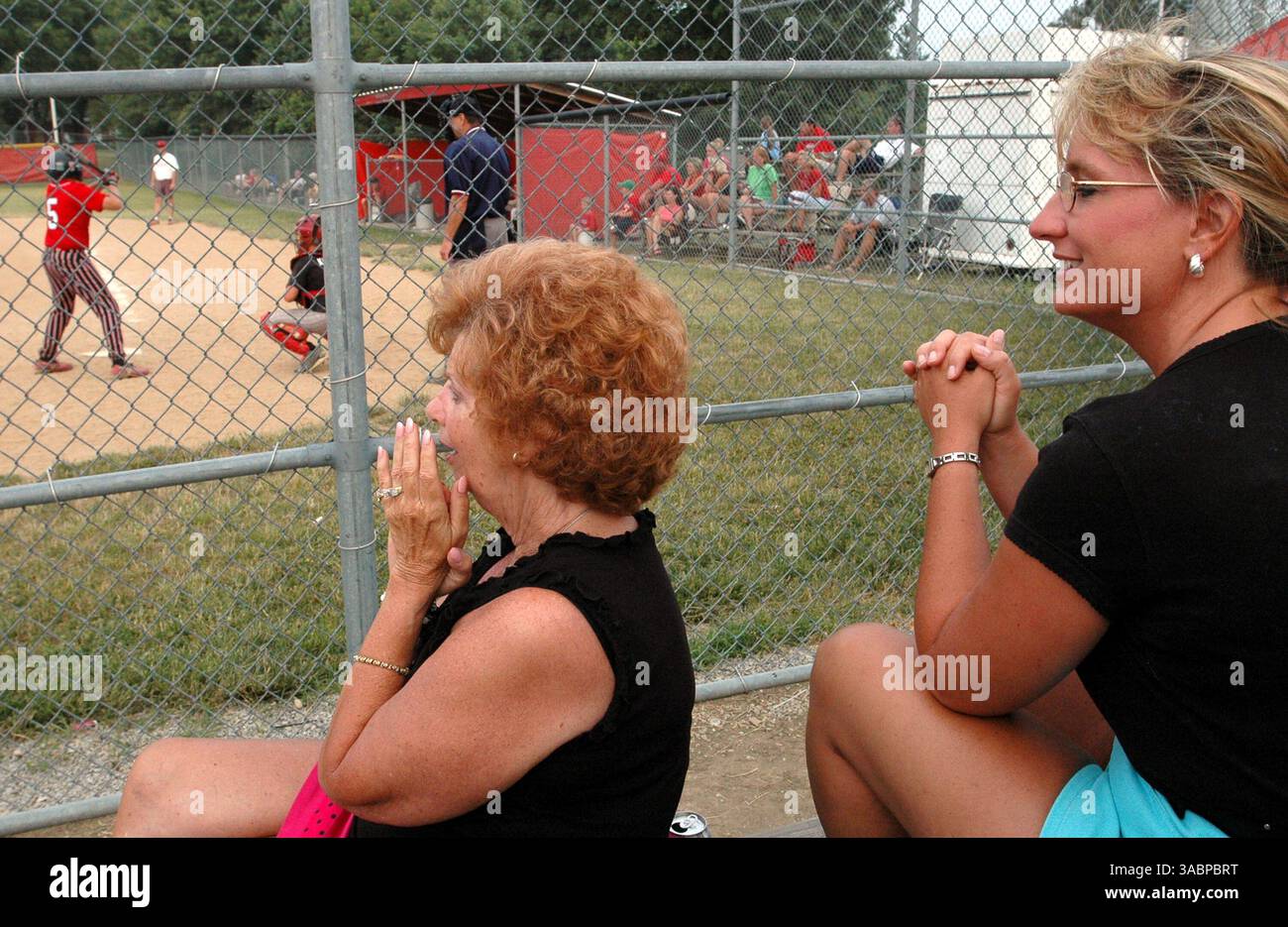 Jun 28, 2005 - Cincinnati, Ohio, USA - 'Baseball Mom' MARLA AVERBECK, (R), of  White Oak,  watches her 13 year old son Zach Dillman #5, take the plate, for The Four In One Cards team in a Tuesday evening game played at Colerain High School.  Also watching the game is GAIL RIEDER, (L), of Colerain Township, to cheer her twin grandsons, playing for the same team.  Colerain Township is one of the twelve townships of Hamilton County, Ohio, United States. The township is composed of  gentle wooded hills separating the Mill Creek and Great Miami River basins, sloping down to the flood plain of the M Stock Photo