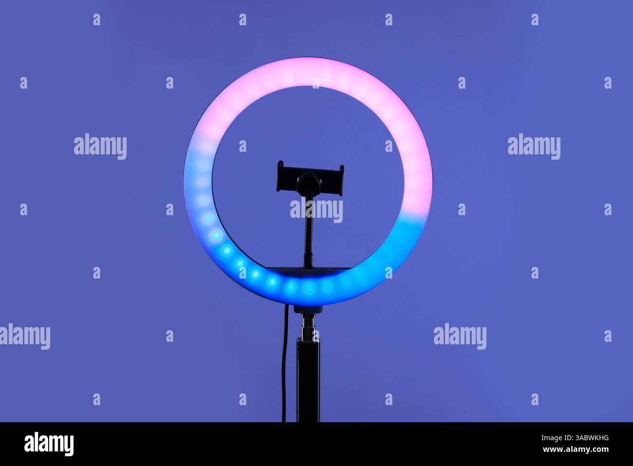 Ring lamp with holder for smartphone against purple background Stock Photo