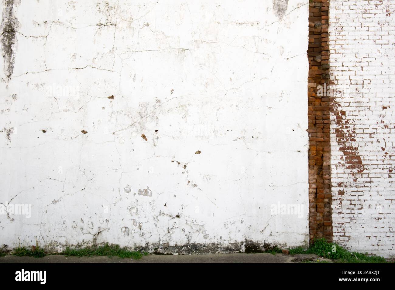 Damaged exterior wall with exposed brick Stock Photo