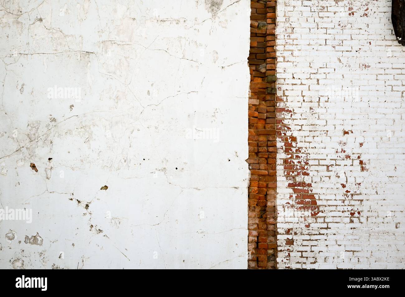 Damaged exterior wall with exposed brick Stock Photo